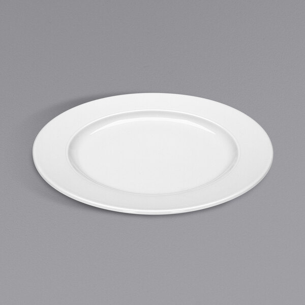 A Bauscher bright white porcelain plate with a wide rim on a gray surface.