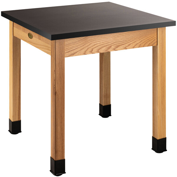 A National Public Seating science lab table with a black phenolic top and wood legs.