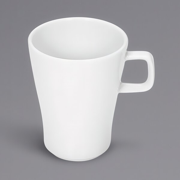 A Bauscher bright white tall cup with a handle on a grey surface.
