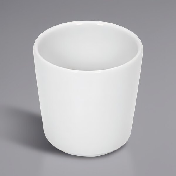 A Bauscher bright white porcelain cup on a gray surface.