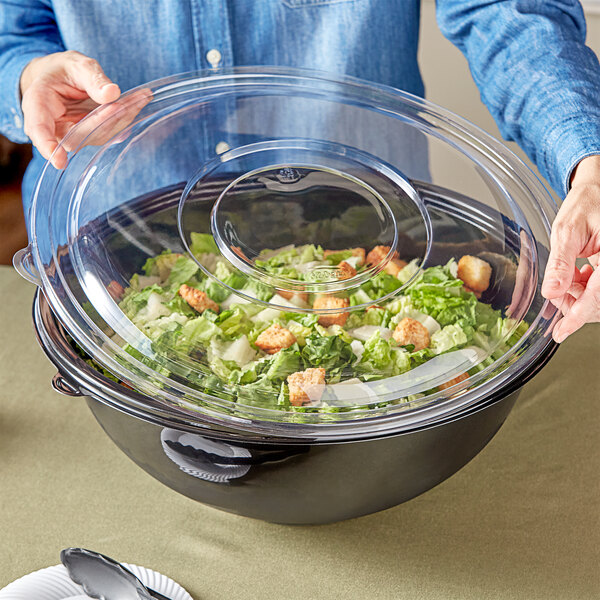 a clear plastic container with a lid on top of a salad