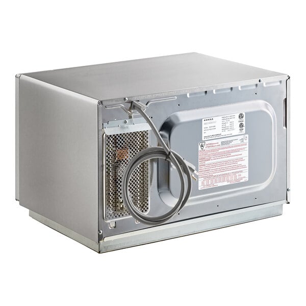 The image shows the back view of a stainless steel microwave oven with a coiled power cord and a vented panel.