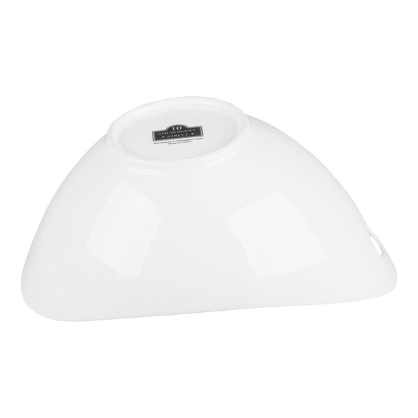 A white porcelain serving bowl with cut outs, shown upside down.