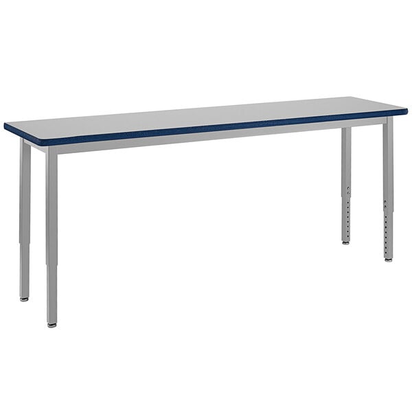 A long rectangular table with silver legs and a gray top.