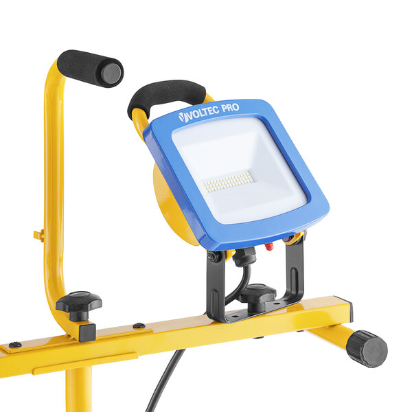 A blue and yellow Voltec LED work light on a stand.