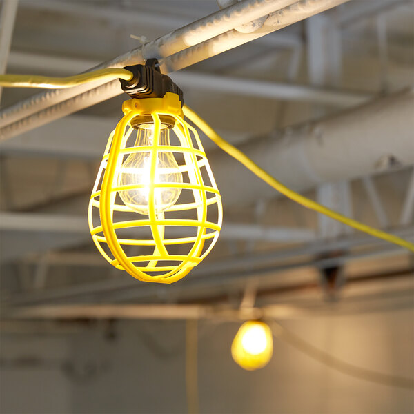 A Voltec U-Ground work light with a yellow light bulb in a plastic cage.