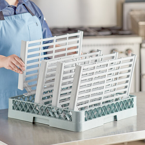 A woman holding white plastic panels with several white plastic crates on a Regency wire shelving kit.