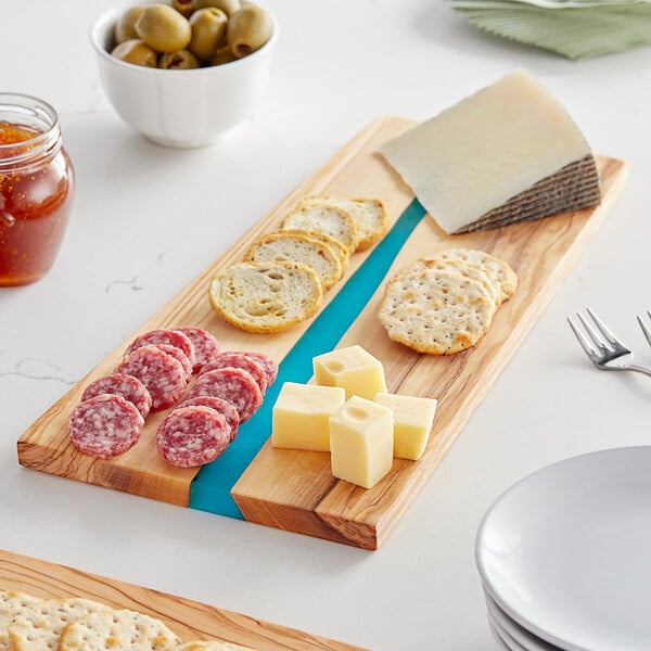 An American Metalcraft rectangular olive wood serving board with cheese and crackers on it.