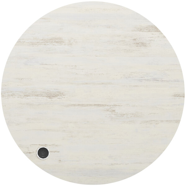 A white round BFM Seating melamine table top with a black wireless charger.
