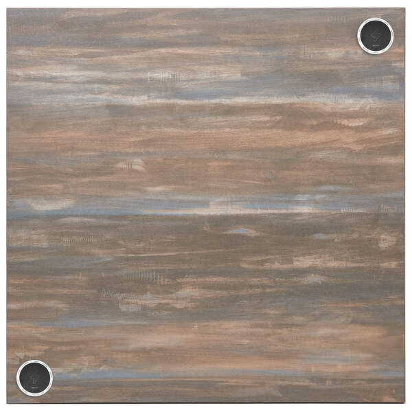 A chestnut brown BFM Seating table top with two black and white wireless chargers.