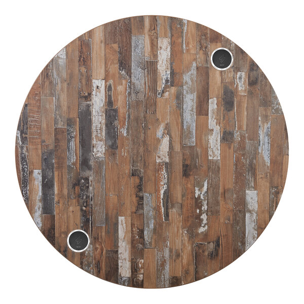 A BFM Seating Midtown round wooden table with two circular holes in it.