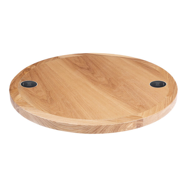 A BFM Seating round natural ash veneer wood table top with two wireless chargers.