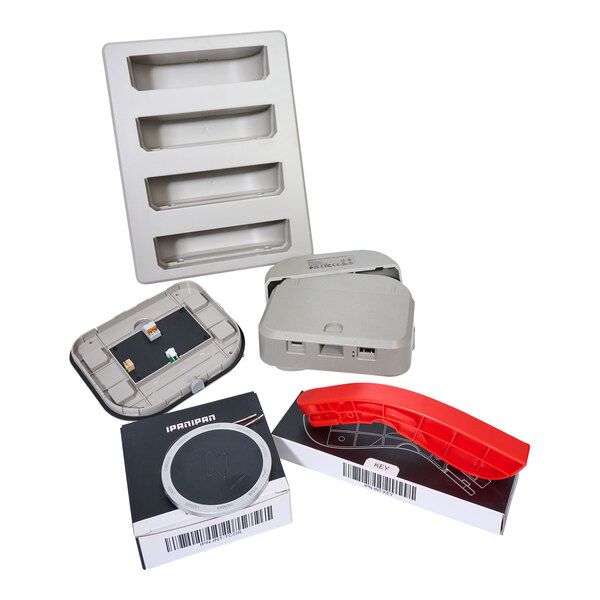 A white plastic tray with four rectangular holes designed for tabletops with a rectangular grey wireless charging station on top.
