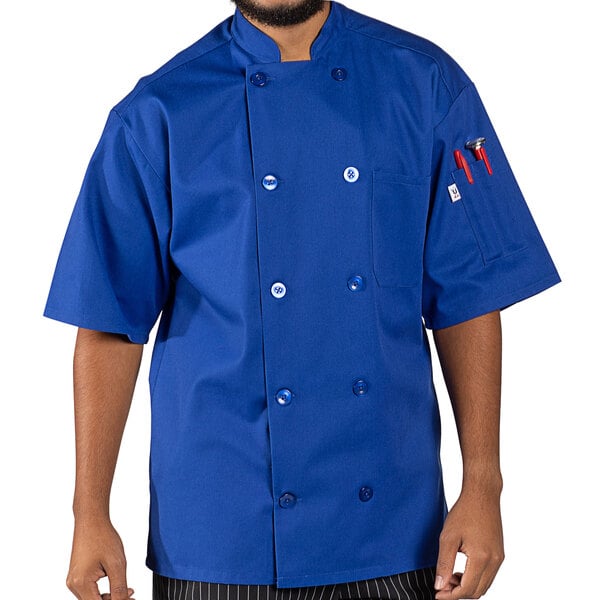 A man wearing a blue Uncommon Chef short sleeve chef coat with royal blue trim.