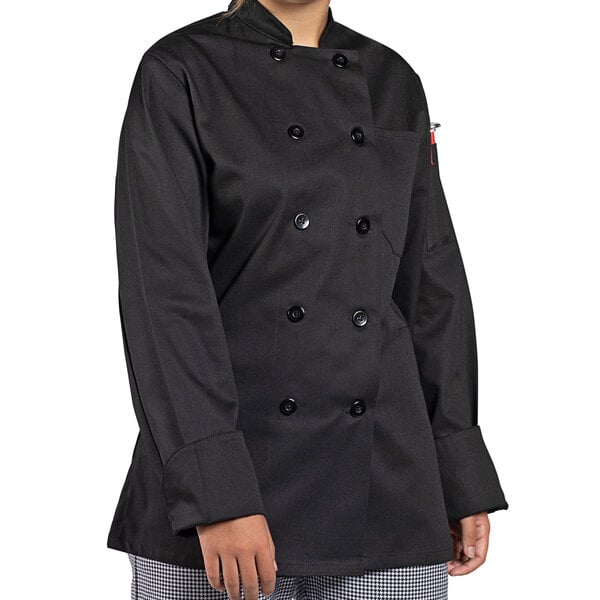 A woman wearing a black Uncommon Chef long sleeve chef coat.