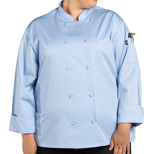 A woman wearing an Uncommon Chef sky blue long sleeve chef coat with mesh back.