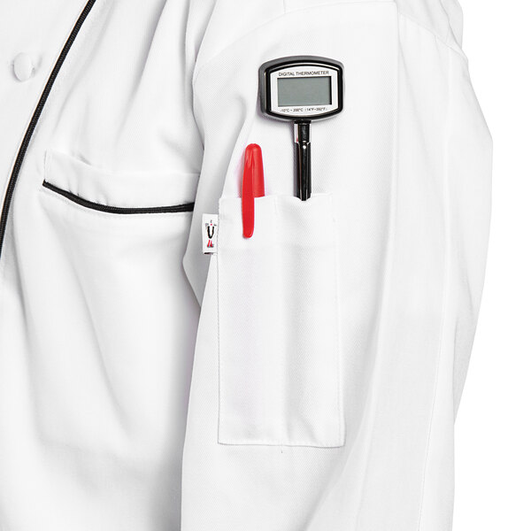 A person wearing a white Uncommon Chef Murano chef coat with black piping and a pen in the pocket.