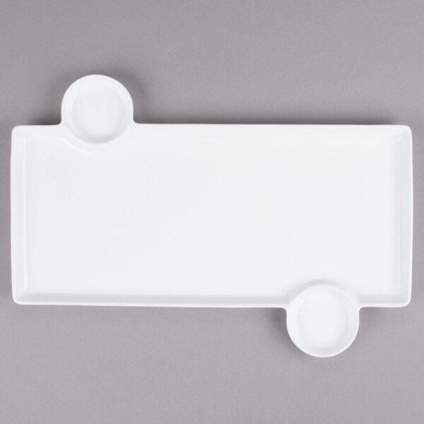 A white rectangular tray with two round objects.