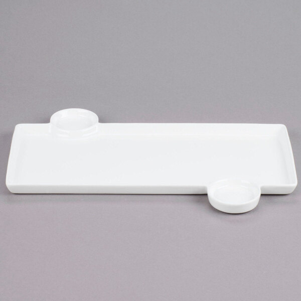 A white rectangular porcelain tray with two built-in round sauce cups.