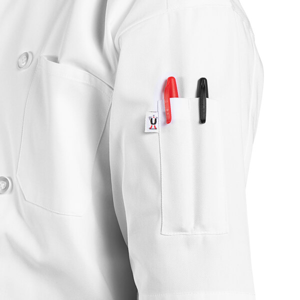 A person wearing a white Uncommon Chef Montego Pro Vent chef coat with a pen in the pocket.