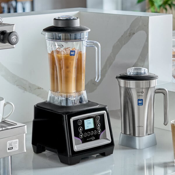 A commercial blender with a digital touchpad control base, a large polycarbonate blending jar filled with a beverage, and an additional stainless steel jar beside it.