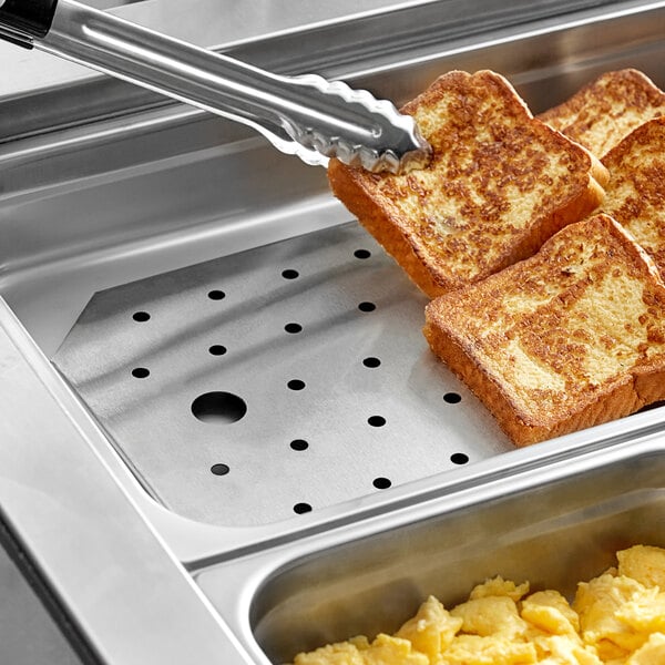 A stainless steel steam table pan false bottom inside a food pan.