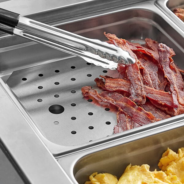 A stainless steel false bottom in a hotel steam table filled with bacon.