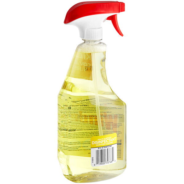 A close-up of a SC Johnson Windex spray bottle with yellow liquid and a red cap.