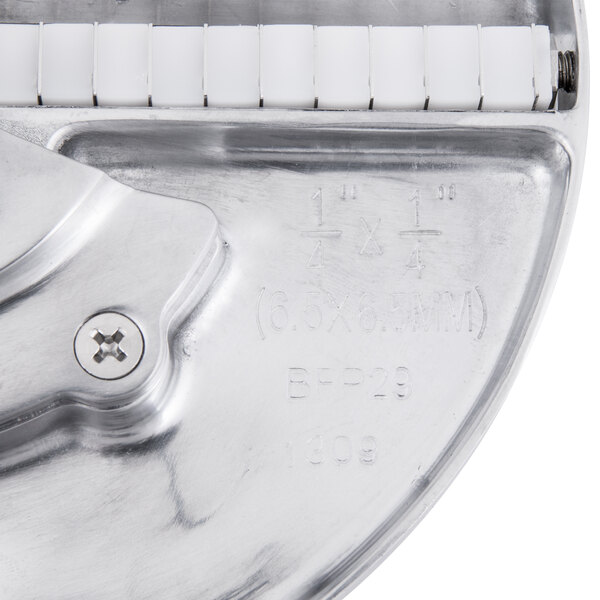 A close-up of a Waring metal julienne disc with a screw.