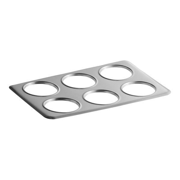 A rectangular metal plate with six evenly spaced circular cutouts.