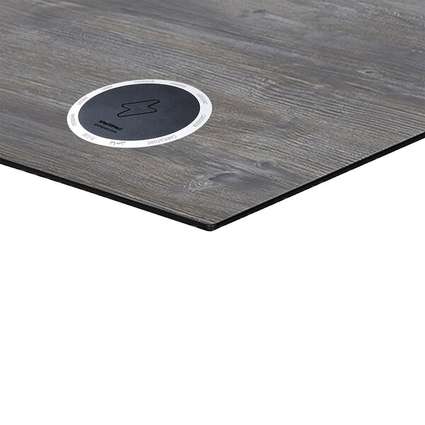 A BFM Seating driftwood composite laminate square table top with a black and white circle on it.