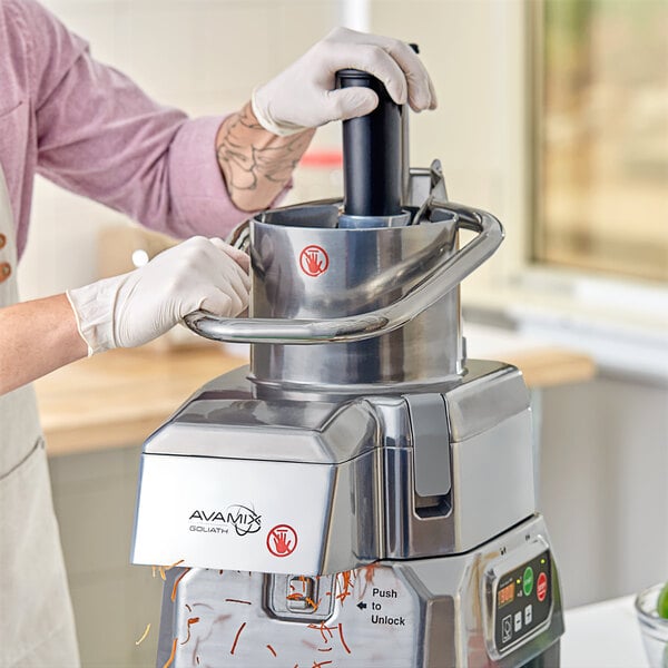A person using an AvaMix continuous feed head to make a salad with a food processor.