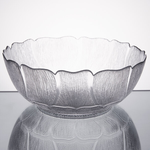 An Arcoroc clear glass bowl with a flower design.