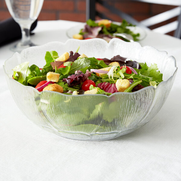 A table set with a salad in an Arcoroc glass bowl.