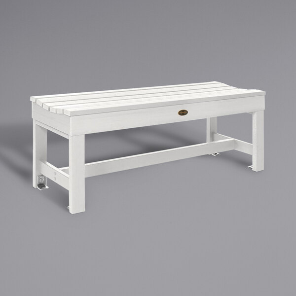 A white backless bench with a slatted seat.