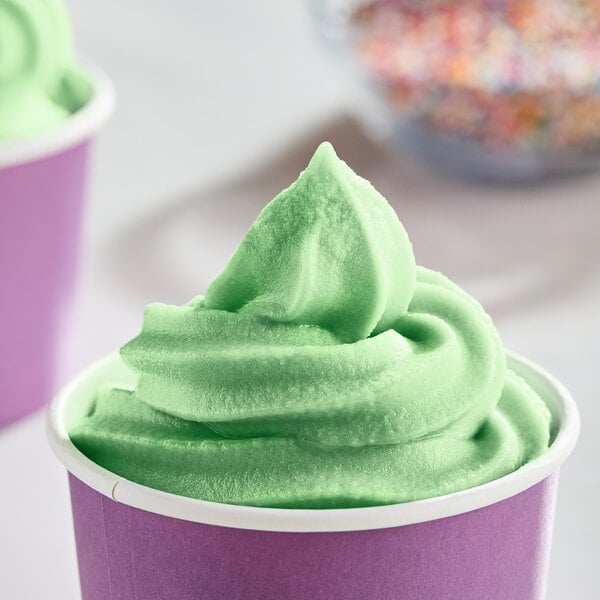 A cup of green DOLE Lime soft serve with sprinkles.