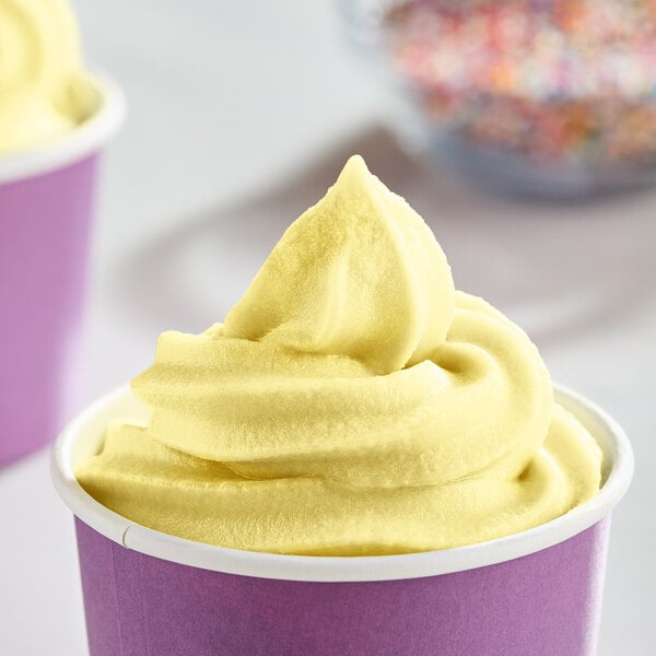 A close up of yellow soft serve in a cup.