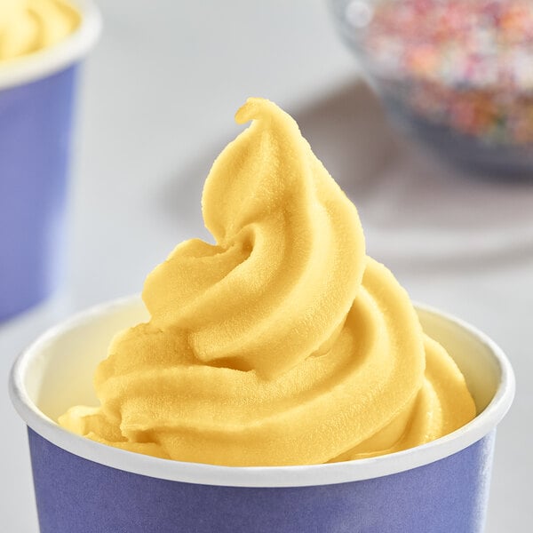 A bowl of yellow DOLE Mango soft serve with sprinkles.