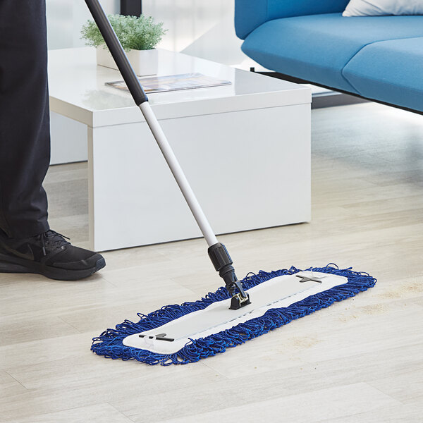 A person using a Lavex microfiber mop pad to clean a floor.