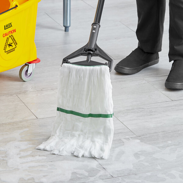 A person cleaning the floor with a white Lavex microfiber wet mop.