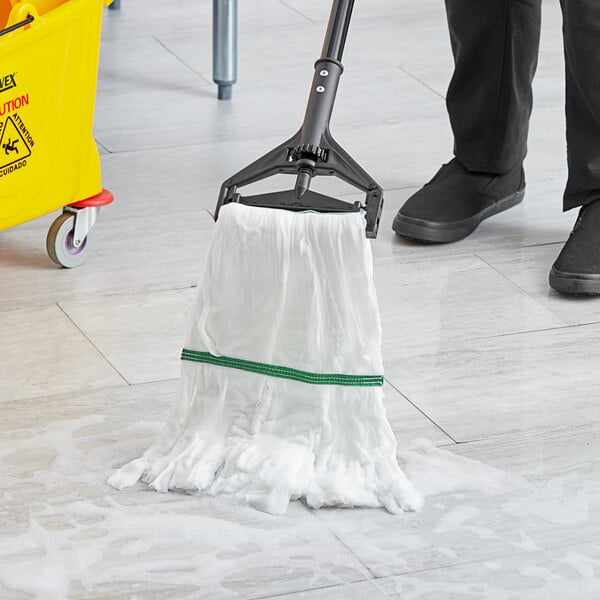 A person using a Lavex white microfiber mop to clean a floor.