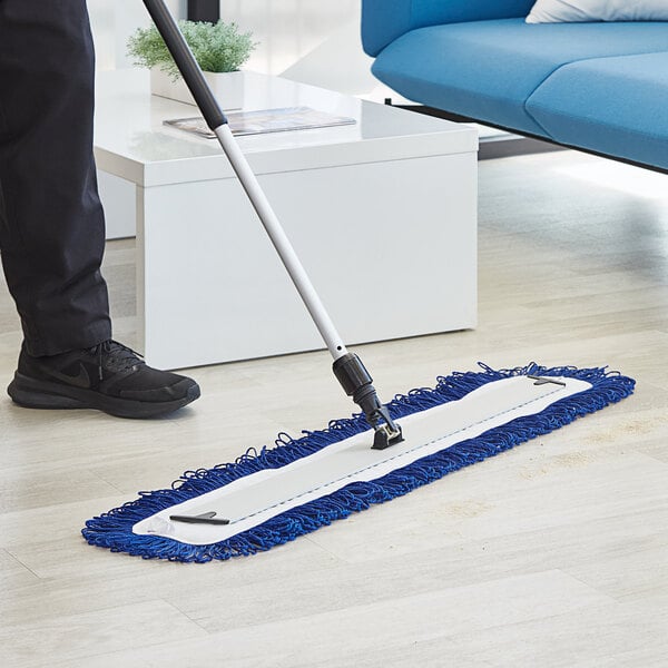 A person using a Lavex microfiber mop pad to clean a floor.