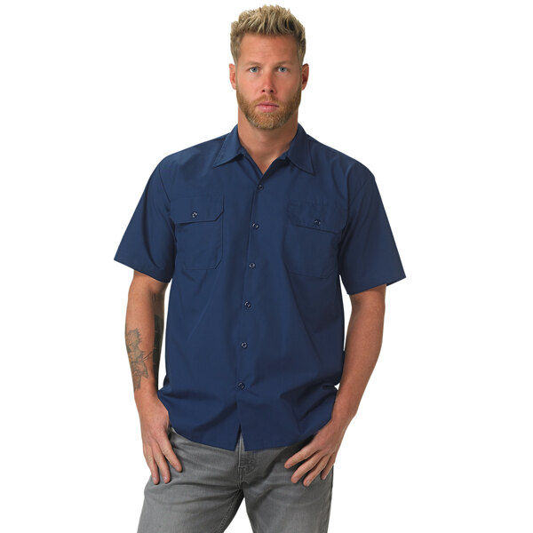 A man with a beard wearing a navy blue Mercer Culinary work shirt.