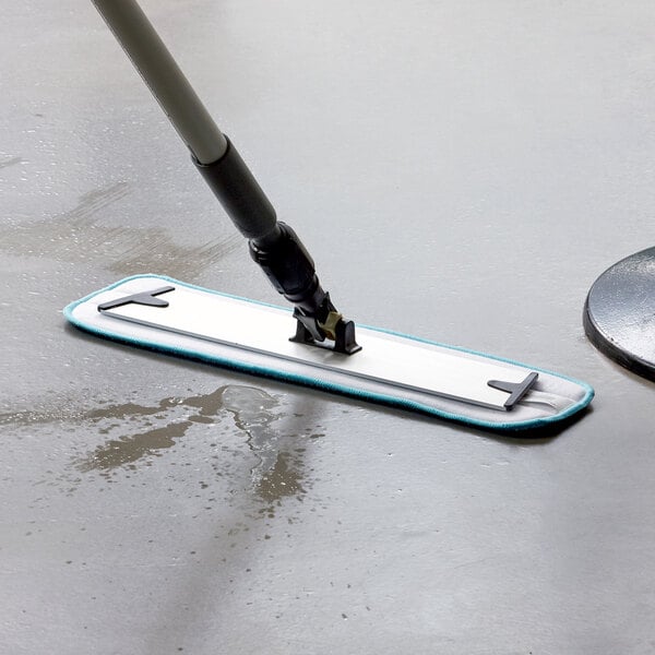 A Lavex blue aluminum mop handle being used to clean a floor.