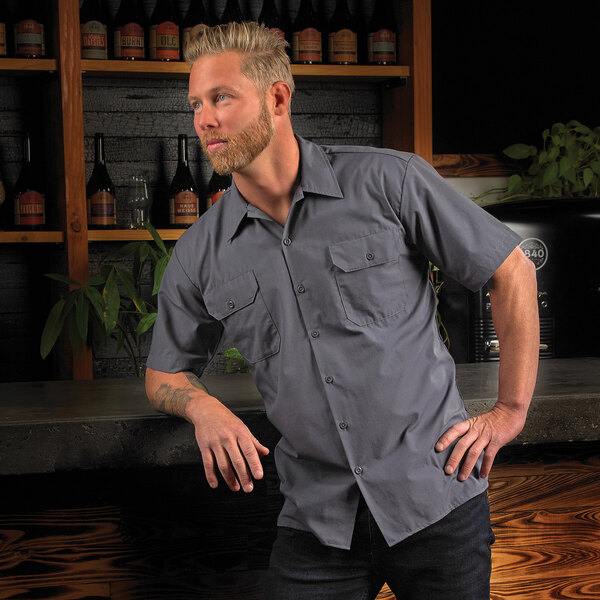 A man wearing a Mercer Culinary gray short sleeve work shirt.