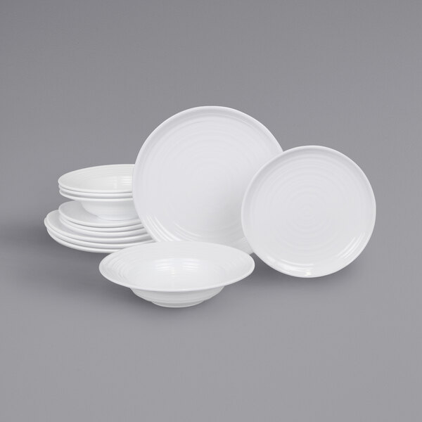 A stack of white plates and bowls with a white plate on top.