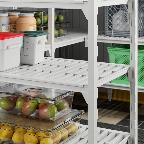 A Cambro Camshelving® Premium stationary unit with 5 vented shelves holding fruit and vegetables.