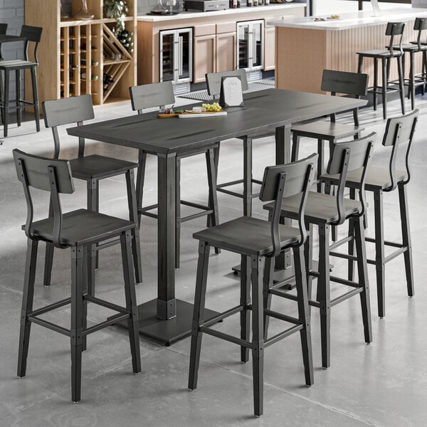 A Lancaster Table & Seating live edge bar height table with chairs around it.