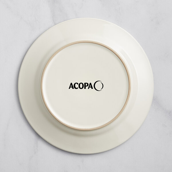 An ivory stoneware plate with the word Acopa embossed on the rim.
