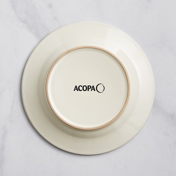An ivory stoneware plate with an embossed wooden rim and the word Acopa on it.